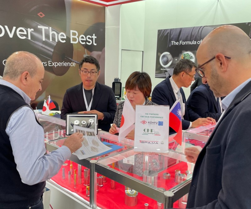 A display of precision fastener forming tools and metal parts at the KONFU booth during the trade show.